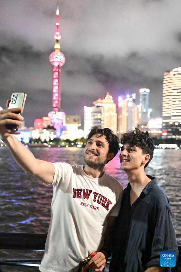Turisti italiani si scattano una foto con la Shanghai Oriental Pearl Tower nella zona del Bund a Shanghai, Cina orientale. (18 luglio 2025 - Xinhua/Chen Haoming)